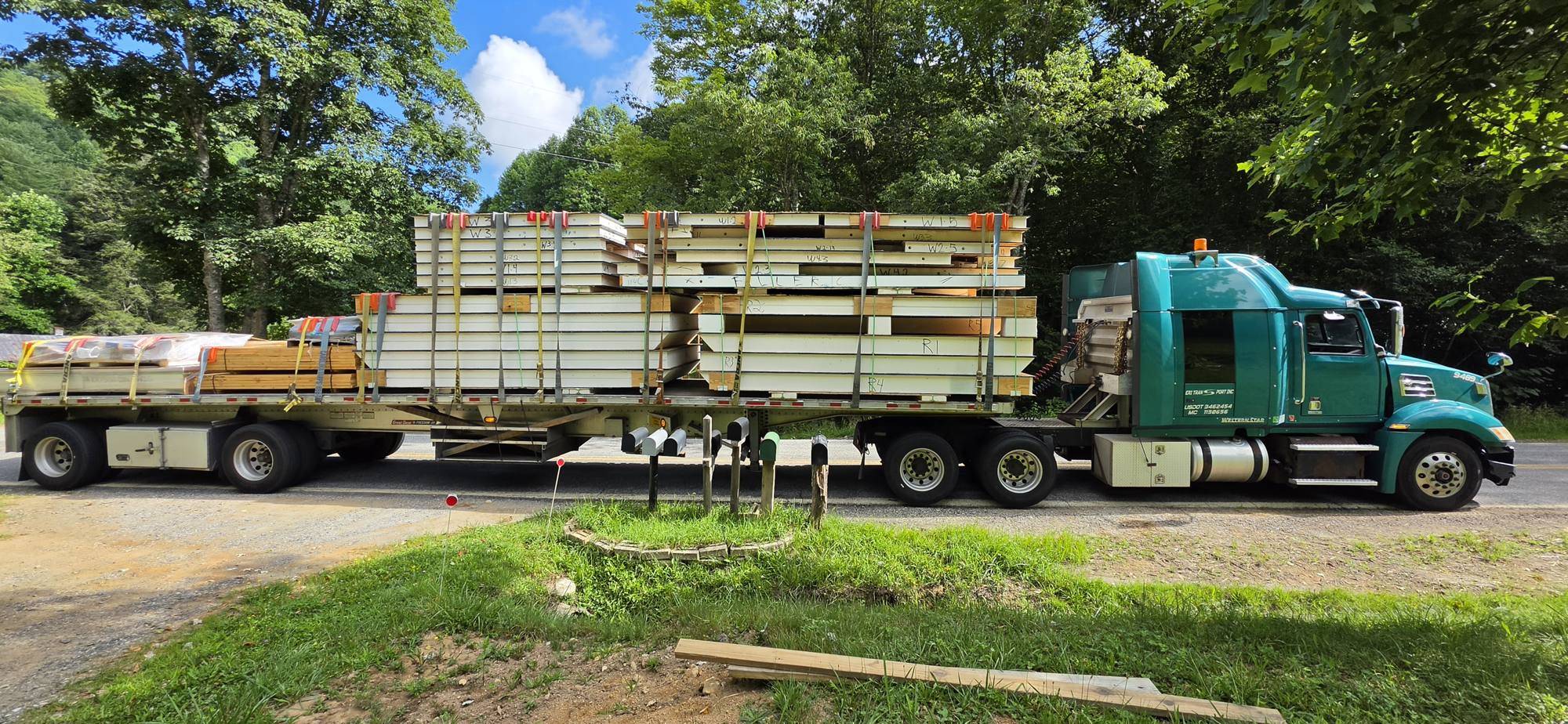 Second flatbed loaded with wrapped SIP panels