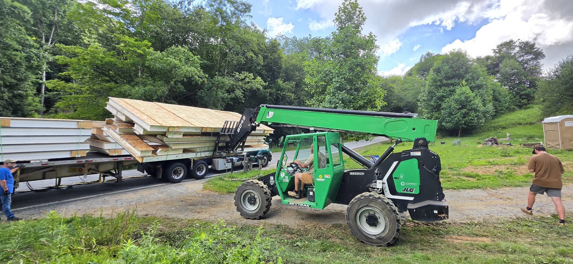 Telehandler carrying SIP panels from the truck to the site