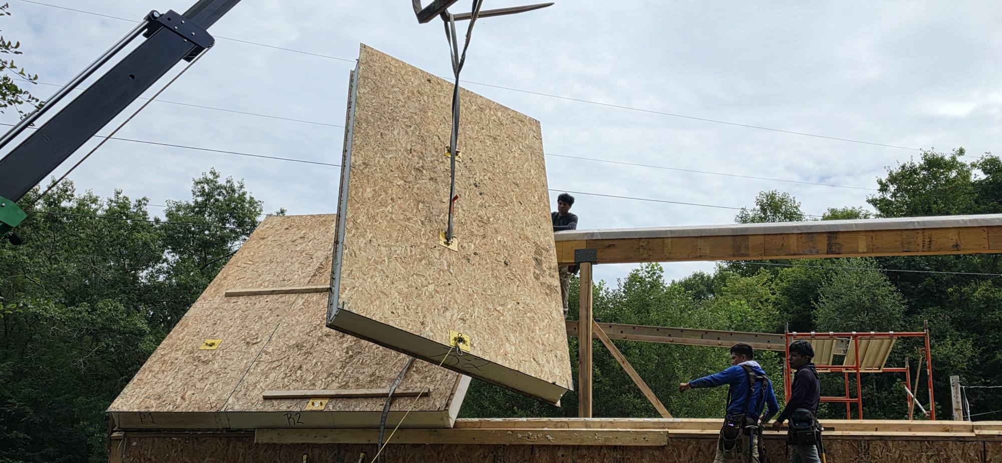 A SIP roof panel lifted into place by crane